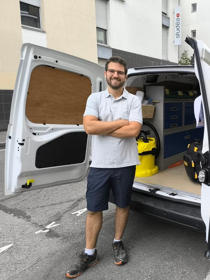 Cyril le Plombier devant son camion à Lyon, portes ouvertes sur son atelier mobile